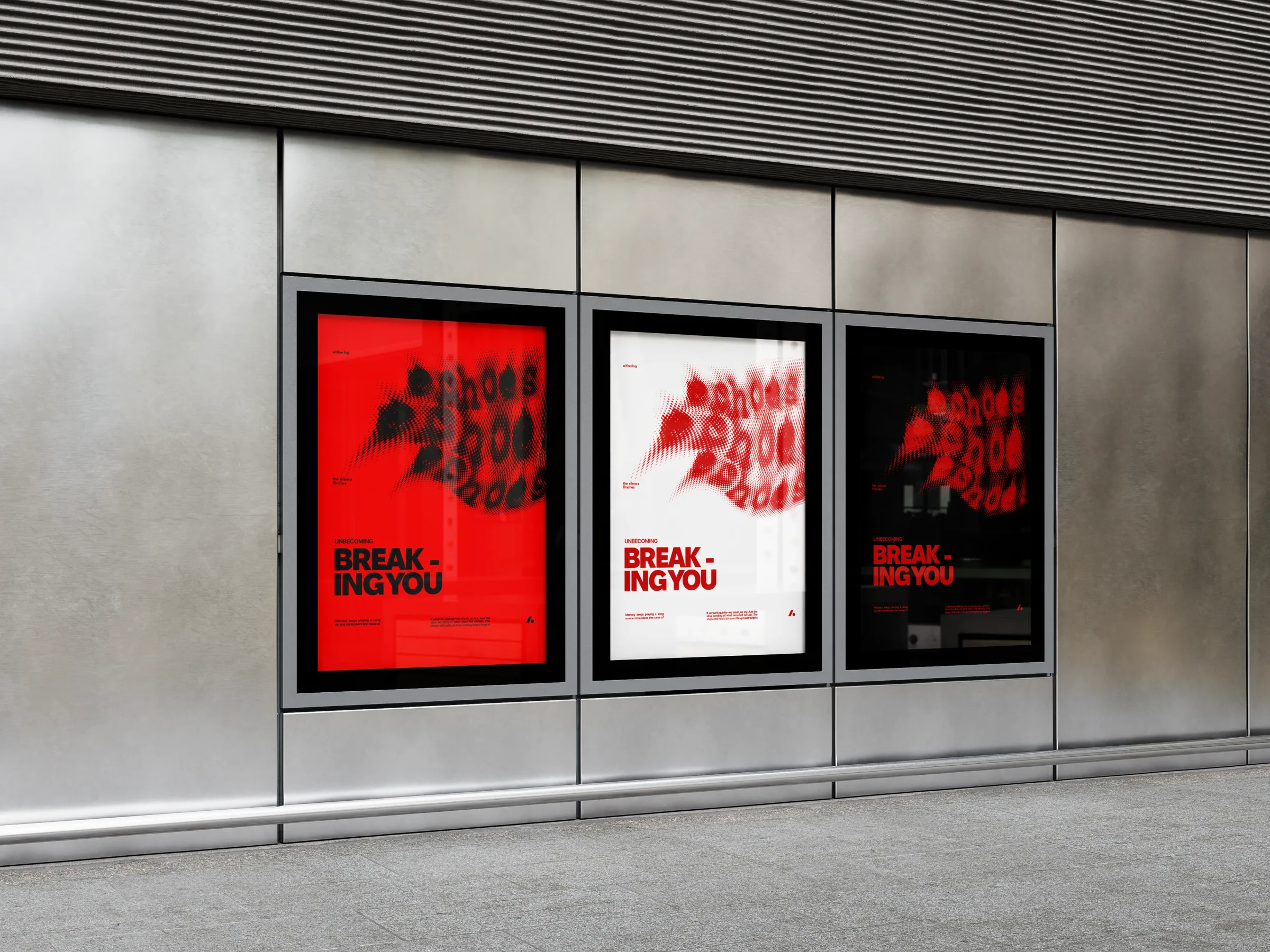 Three Breaking You posters side by side in a lit street window, two red and one white.